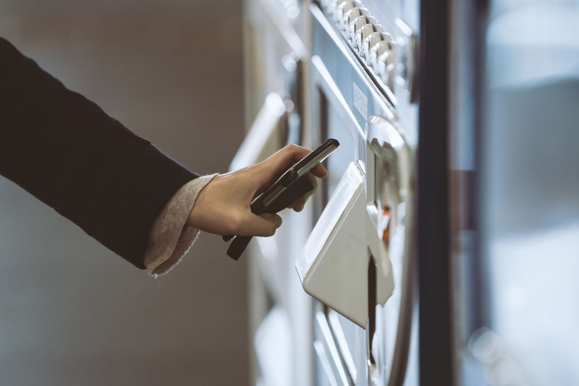 Woman buying with a vending machine